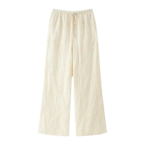 Détail du pantalon large blanc avec broderie florale en 3D et taille élastique à cordon
