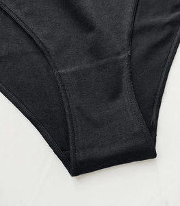 Detailed close-up of double-stitched seams and breathable cotton fabric on black panties