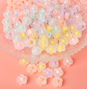 Macro dettagliata di perle a fiore in acrilico opaco pastello su un vassoio di vetro
