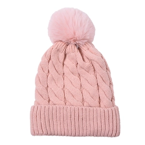 Close-up of pink cable knit hat featuring a large soft faux fur pom-pom on top
