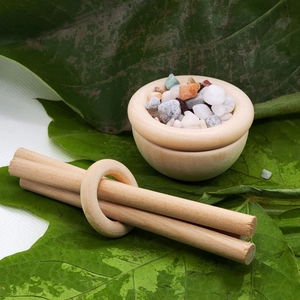Detail of a natural wood diffuser bowl with colorful stones and essential oil wood sticks