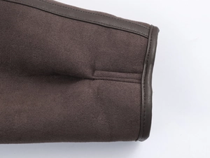Detail of brown suede jacket showing fine stitching and faux leather trim at the cuff