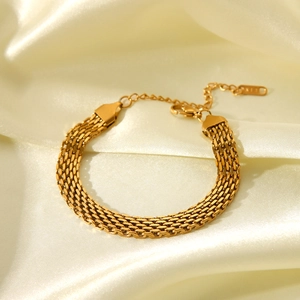Detailed view of golden watchband link chain bracelet on elegant white satin background