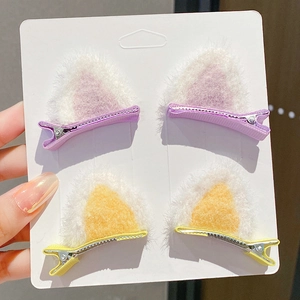 Cute plush cat ear hair clips in purple and yellow colors on display card