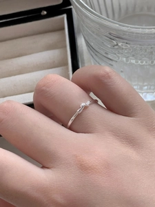 Close-up of a silver S925 heart-shaped ring with pavé diamonds on a woman's finger