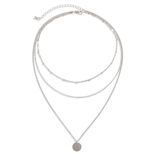Detailed view of triple-layered silver chain necklace with a smooth round metal pendant