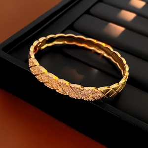 Macro detail of gold quilted bangle featuring sparkling pavé zircon stones on cross pattern