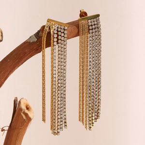 Detail of 18K gold plated tassel earrings with sparkling rhinestones on wood branch