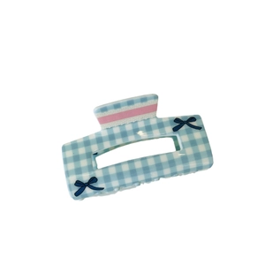 Checkered blue acrylic hair claw clip with pink ribbon and bow accents for women