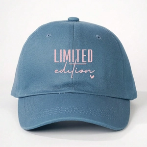 Close-up of pink LIMITED edition lettering and heart embroidery on navy cotton baseball cap