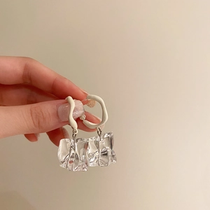 Detail showing irregular frosted acrylic hoops with transparent geometric drop pendants