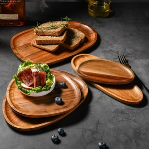 Handcrafted acacia wood serving trays in various oval shapes with natural grain patterns