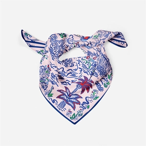 Detail of pink silk scarf with blue hand-painted floral pattern and a stylish knot