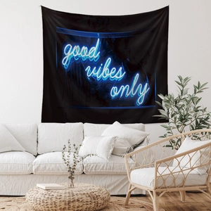 Detail of Good Vibes Only neon lettering on black bohemian tapestry in a modern living room