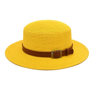 Vista detallada de un vibrante sombrero de paja amarillo con cinturón y hebilla marrón.