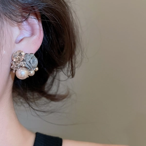 Detailed close-up of vintage flower earrings with faceted crystal and pearls