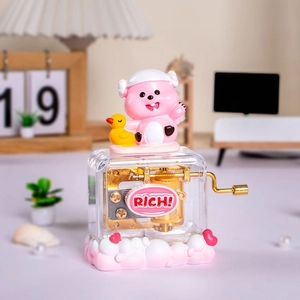 Nahaufnahme der rosa Loopy Spieluhr mit Handkurbel auf einem gemütlichen Schreibtisch