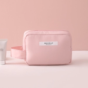 Pink waterproof nylon makeup bag with top handle and MAKEUP BEAUTY label on front