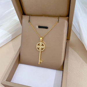 Luxurious gold flower key pendant necklace with crystals on a jewelry display box