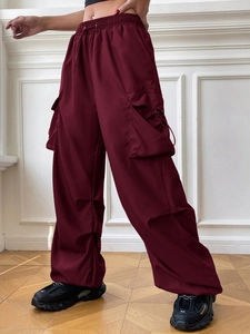 Detail view of burgundy cargo pants featuring high waist drawstrings and large side pockets