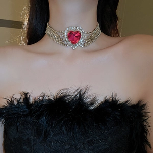 Macro shot of gold five-row rhinestone choker with large red heart crystal on neck