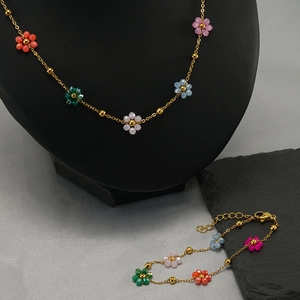 Gold chain jewelry set with colorful floral bead charms on a professional display
