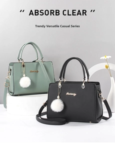Detail of dark green and black tote bags featuring gold hardware and plush charm
