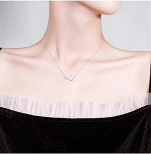 Close-up of a delicate S925 sterling silver dove pendant necklace on a female model
