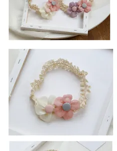 Close-up of soft lace baby headband featuring handmade fabric flowers and round buttons