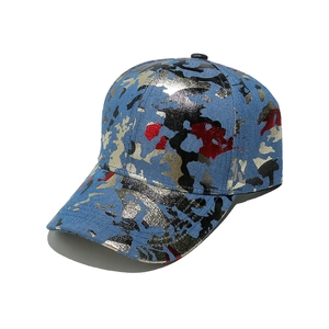 Close-up of metallic camo print on blue denim baseball cap with gold foil details
