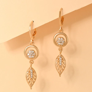 Detailed close-up of champagne gold leaf earrings with sparkling white cubic zirconia
