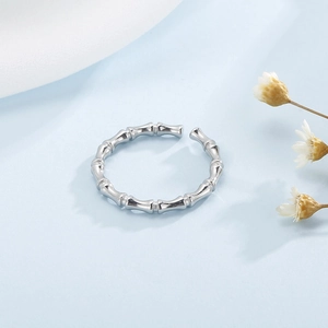 Close-up of silver bamboo style open ring with polished metal texture and elegant details