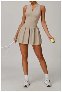 Détail d'une robe de tennis beige sans manches avec col en V zippé et jupe plissée sport