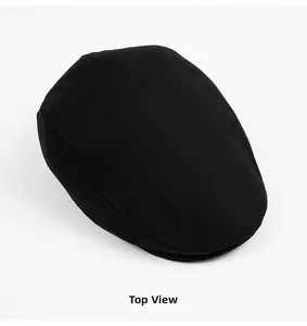 Top view detail of a classic black cotton flat cap showing fine woven texture and stitching