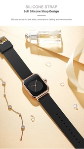 Detail of rose gold square watch case with black silicone strap and luxury accessories