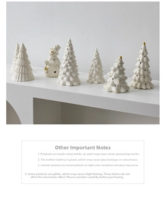 Detailed close-up of white ceramic Christmas tree ornaments and a snowman with gold accents