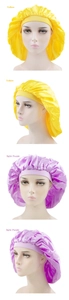 Detail view of large satin sleep bonnets in yellow and light purple colors
