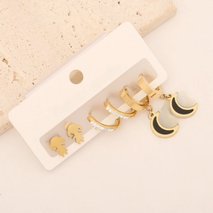 Detailed set of gold heart studs, crystal earrings, and black moon pendant jewelry