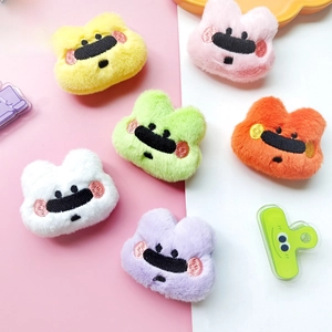 Close-up of colorful plush bear head accessories with detailed embroidery in six vibrant colors