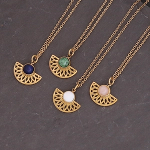Golden sunflower cross pendant necklaces with colorful gemstones on a slate background