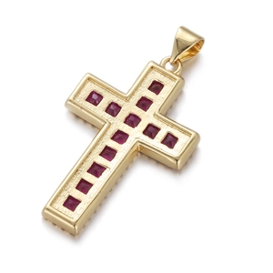 Macro detail of a gold cross pendant featuring square-cut red zircon gemstones