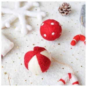 Macro shot of handmade wool felt Christmas ornaments with red and white polka dots and patterns