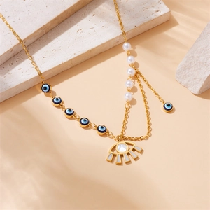 Gold layered evil eye necklace with pearls and eye pendant on textured stone