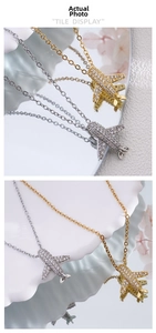 Macro shot of gold and silver airplane pendants with sparkling pavé cubic zirconia