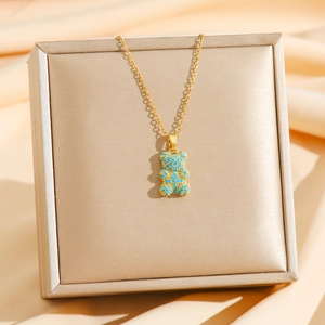 Primer plano del collar de oso dorado con piedras azules en una caja de joyería fina