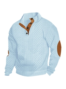 Detail of light blue knit sweater with brown button trim and reinforced elbow patches