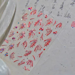 Vista macro de pegatinas de uñas 3D en rojo y plateado con fuegos artificiales en seda blanca