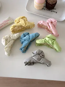 Detail of colorful fabric pleated hair claws in six low-saturation pastel colors for women