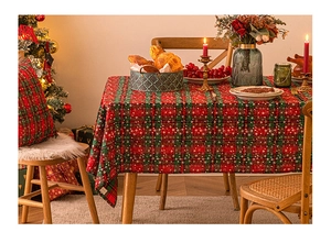 Detail of red and green plaid Christmas tablecloth with festive snowflake prints and pillows