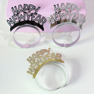 Close-up of Happy New Year tiaras in gold, silver, and black with glitter texture
